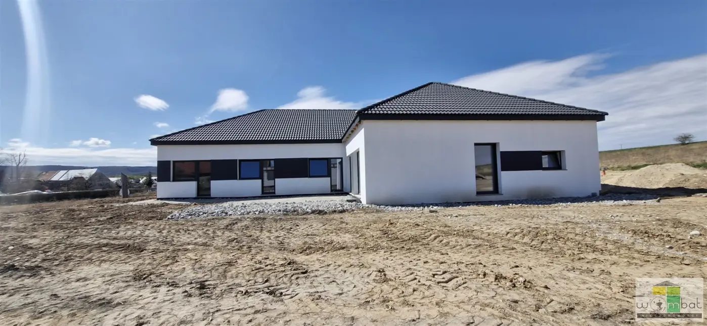 Nowoczesny dom parterowy w zabudowie bliżniaczej.