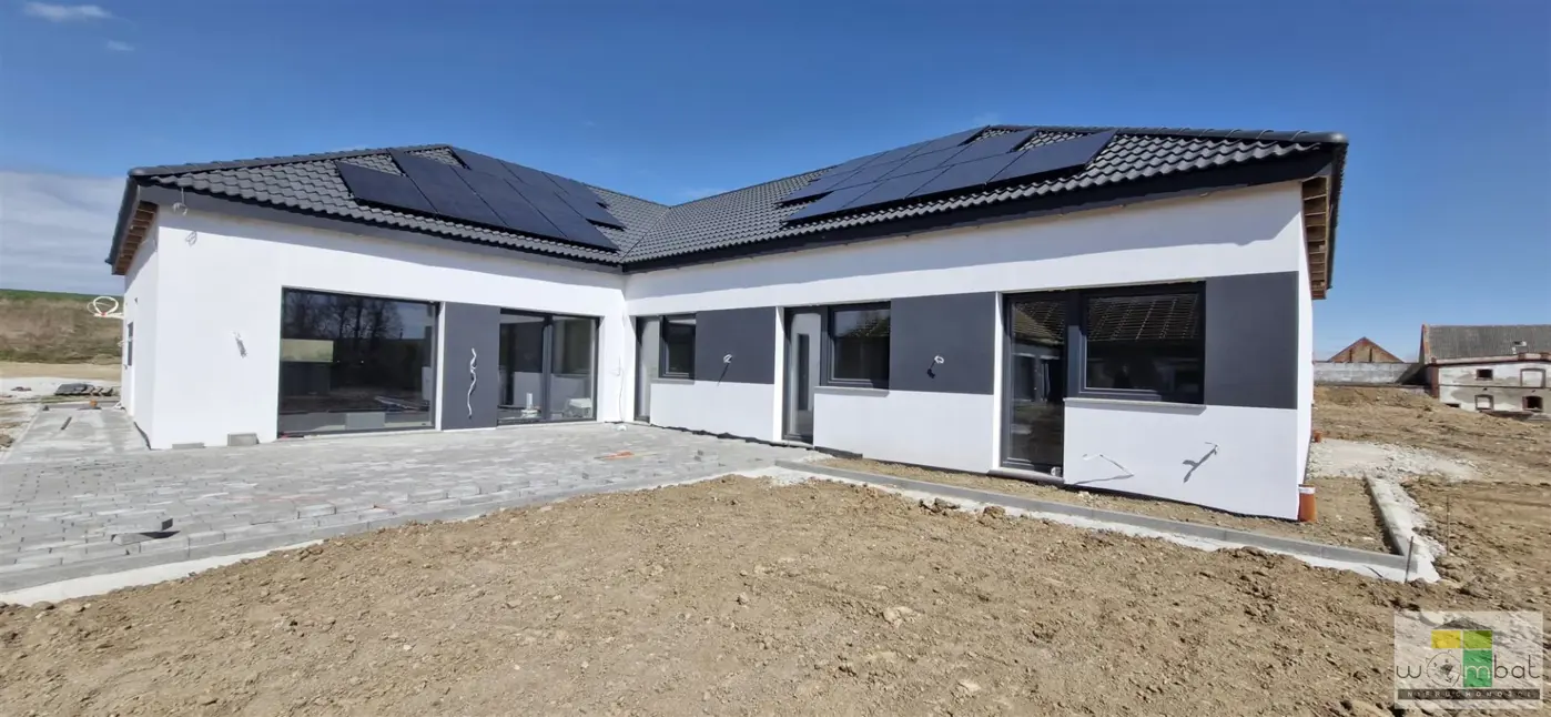 Nowoczesny dom parterowy w zabudowie bliżniaczej.